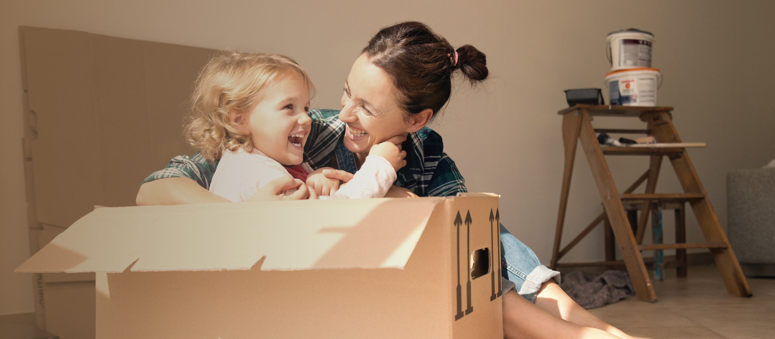 woman playing with little girl in a moving box